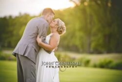 Bride and groom sharing a romantic kiss outdoors at sunset