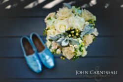 Bouquet and blue shoes on wooden floor.