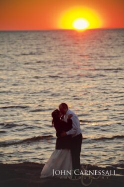 Bride and groom standing side by side by the water at Bayshore Grove Oswego NY