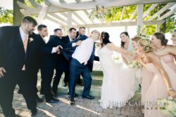 Bride and groom tugged by bridal party
