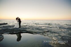 Bride and groom sunset portrait by the water at Bayshore Grove in Oswego NY