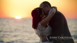 Bride and groom hugging by the water in soft evening light at Bayshore Grove Oswego NY