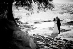 Bride and groom holding each other by the waterfront at Bayshore Grove Oswego NY