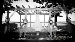 Wedding dress hanging under decorative pergola.