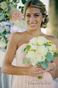 Woman holding bouquet at outdoor event.