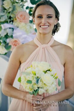 Smiling woman holding bouquet at wedding.
