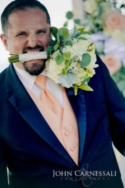 Man with bouquet in mouth at event.