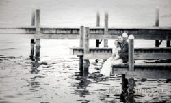 Couple embracing on lakeside wooden dock.