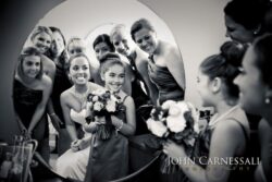 Flower girl and bridesmaids gathered around mirror