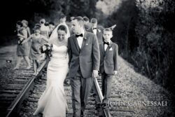 Newlyweds strolling along railroad tracks