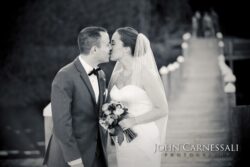 Bride and groom embracing by the lake at Belhurst Castle Geneva NY, Finger Lakes wedding day portraits