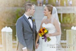 Wedding couple holding hands by Seneca Lake at Belhurst Castle in Geneva NY, Finger Lakes wedding portrait