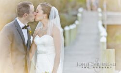 Wedding couple standing at the waterfront railing at Belhurst Castle Geneva NY, Seneca Lake wedding portrait