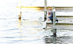 Newlyweds embracing on a sunlit dock
