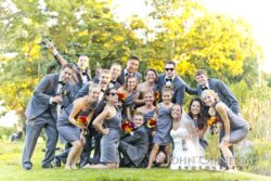 Wedding party posing playfully in a park.