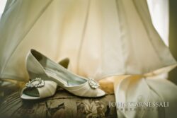 Wedding shoes beneath a bridal gown.
