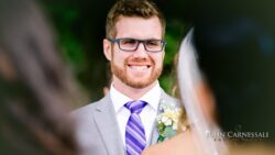 Smiling groom in glasses at wedding ceremony.