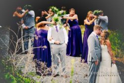 Wedding couple kissing, bridal party covering faces.