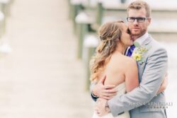 Bride and groom holding each other by the lakeshore at Belhurst Castle Geneva NY, Seneca Lake wedding day photo