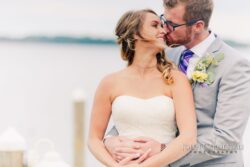 Wedding couple holding each other with Seneca Lake in the background at Belhurst Castle in Geneva NY