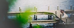 Groom dipping bride for kiss on wooden dock