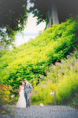Wedding couple hugging by the water background at Belhurst Castle Geneva NY, Seneca Lake