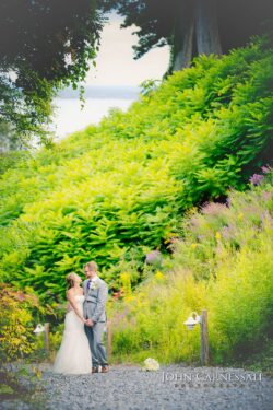 Newlyweds embracing on gravel path