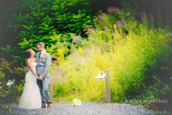 Bride and groom walking in the grass at Belhurst Castle in Geneva NY on their wedding day, Finger Lakes portraits