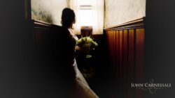 Bride silhouetted by window with flowers.