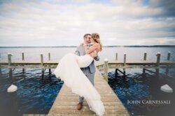 Groom lifting the bride at sunset near the waterfront at Belhurst Castle in Geneva NY, Finger Lakes wedding day photo