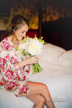Bride holding bouquet in floral robe.