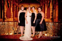 Bride with bridesmaids in ornate venue.