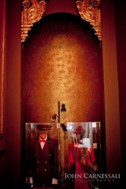 Display of vintage uniforms in ornate alcove.