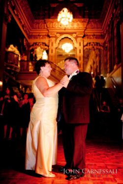 Couple dancing elegantly in ornate venue.