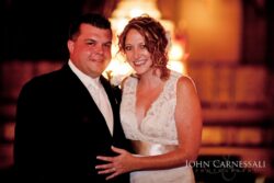 Smiling couple in formal wedding attire.
