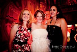 Four smiling women at a festive event.