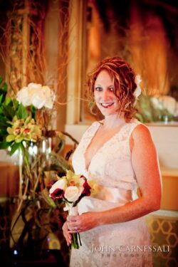 Bride holding bouquet in elegant wedding dress.