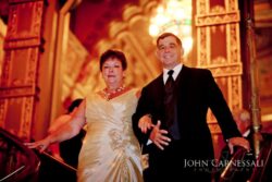 Elegant couple at formal event staircase.