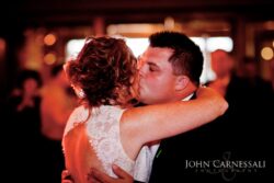 Couple sharing a kiss at wedding reception.