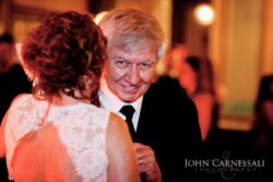 Elderly man smiling at a formal event.