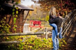 engagement photo of couple embracing near rustic fence with fall colors, countryside engagement session un Syracuse NY