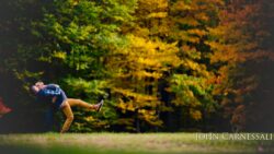 LGBTQ engagement photo of two men standing close in a green park setting, natural candid couple portrait