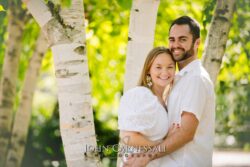 Engagement photo of couple hugging near birch trees with bright natural light, romantic couple portrait