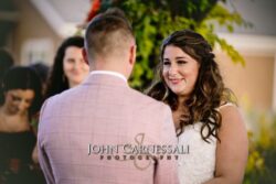 bride crying at wedding ceremony as she holds the grooms hands