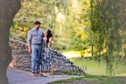 engagement photo of couple walking together down a sunlit path, romantic candid couples portrait
