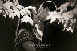 black and white engagement photo of couple kissing in close-up, romantic documentary portrait