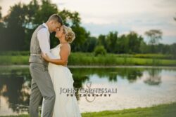Bride and groom embracing by the water