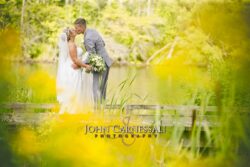 Bride and groom embracing near the water