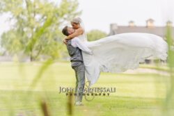 Bride and groom standing beneath a flowing veil