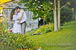 couple embracing in garden beside a barn